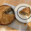 A delicious looking homemade chicken pie with a slice taken out and put on a side plate.