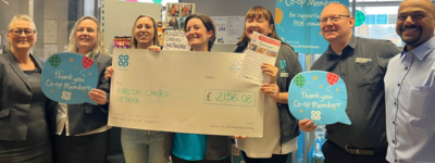 Jo Maye of KCN being presented with a huge cheque by staff at the Co-op