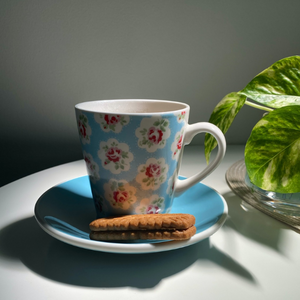 Lovely cup of coffee in a blue mug with a couple of biscuits