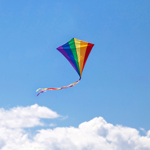 A rainbow kite flying in a bright blue sky