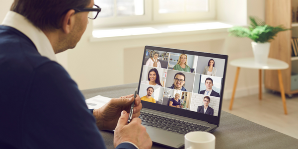 Carer looking at computer screen with a group video call showing